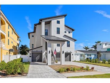 Modern three-story home featuring dual garages, eye-catching architectural details, and a paved driveway at 1843 Bayou Grande Ne Blvd, St Petersburg, FL 33703