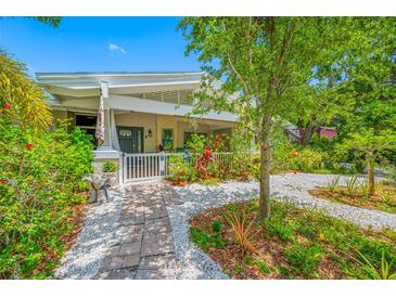 Charming home with a welcoming front porch, lush garden, and brick pathway at 400 5Th S Ave, Safety Harbor, FL 34695