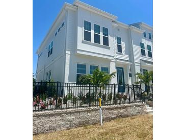 Beautiful two-story townhouse with a manicured front yard, black fence, and blue door at 4717 W Mccoy St # 9, Tampa, FL 33616
