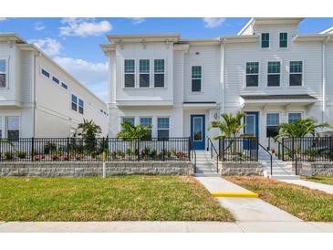 Charming two-story home with a well-manicured lawn, black fence, and a vibrant blue front door at 4717 W Mccoy St # 9, Tampa, FL 33616