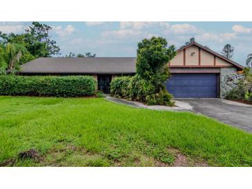 Charming single-story home featuring a lush front lawn, a blue two-car garage and an inviting entryway at 5101 Estates Cir, Sarasota, FL 34243