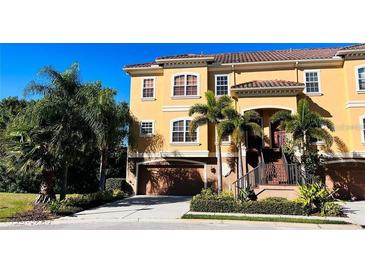 Beautiful three story home with a tile roof, garage, manicured landscaping, and private entrance at 6513 Sand Shore Ln, New Port Richey, FL 34652