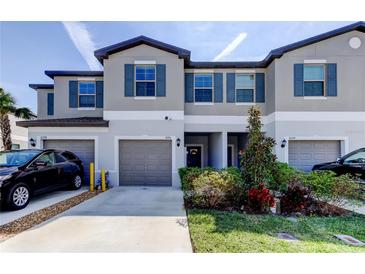 Charming townhome featuring a gray exterior, blue shutters, and well-maintained landscaping at 8294 Corner Pine Way, New Port Richey, FL 34655