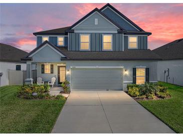 Charming two-story home featuring a gray exterior, landscaped yard, and a spacious two-car garage at sunset at 11232 Bram Bay Ct, San Antonio, FL 33576