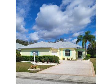 Charming single-story home with a well-manicured lawn, a two car garage, and a welcoming front entrance at 1318 Misty Greens Dr, Sun City Center, FL 33573