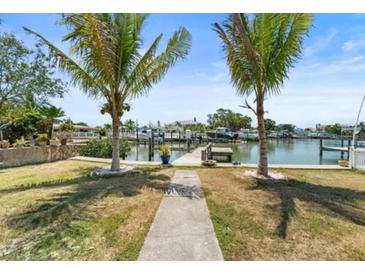 Gorgeous waterfront view with a private dock and lush landscaping perfect for enjoying the waterfront lifestyle at 14184 W Parsley Dr, Madeira Beach, FL 33708