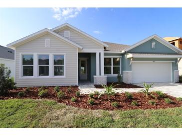 Charming single-story home featuring a manicured lawn, craftsman details, and a welcoming two-car garage at 31430 Hayman Loop, Wesley Chapel, FL 33545