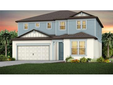 Charming two-story home showcasing a light blue and white color scheme, paired with a two-car garage and inviting front lawn at 37195 Clinch Cir, Zephyrhills, FL 33540