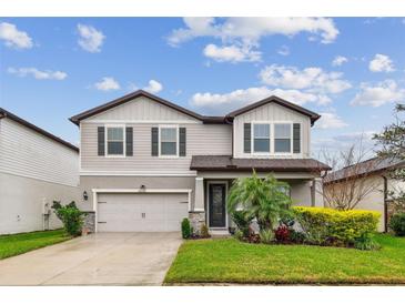 Two-story home with a two car garage, neat landscaping, and a welcoming front entrance at 6228 Dutton Dr, Wesley Chapel, FL 33545