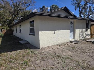 Exterior view of home with a textured stucco facade, dark trim, and a well-defined roofline at 8319 N 14Th St, Tampa, FL 33604