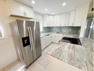 Modern kitchen featuring stainless steel appliances, beautiful countertops, and white cabinets at 3300 Fox Chase N Cir # 229, Palm Harbor, FL 34683