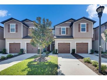 Charming townhomes with attached garages, manicured lawn and beautiful landscaping at 5312 Sylvester Loop, Tampa, FL 33610