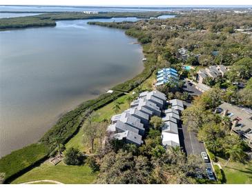Stunning aerial view of waterfront condos, lush landscaping, and tranquil bay waters at 1111 N Bayshore Blvd # F11, Clearwater, FL 33759