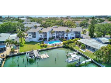 Beautiful condo complex featuring waterfront access, a community pool, and lush landscaping at 12055 3Rd E St # 103, Treasure Island, FL 33706