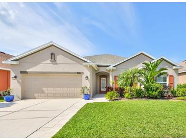 Charming one-story home featuring a well-manicured lawn and tropical landscaping at 1510 Yale Castle Ct, Ruskin, FL 33570