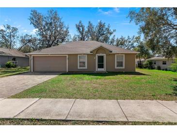 Charming single-story home with an attached two-car garage and a well-maintained front lawn at 2156 Deltona Blvd, Spring Hill, FL 34606
