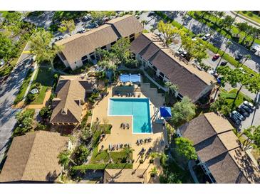 Aerial view of a community pool surrounded by lounge chairs and well-maintained landscaping at 4006 Crockers Lake Blvd # 212, Sarasota, FL 34238