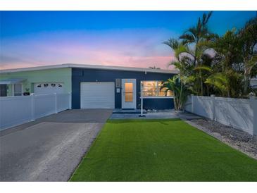 Charming single-story home with a manicured lawn, attached garage, and beautiful landscaping at 423 62Nd St, Holmes Beach, FL 34217