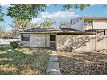 Charming home exterior with a walkway to the front door and a wooden fence creating a private courtyard at 8001 Jasmine Dr # 8001, Temple Terrace, FL 33637