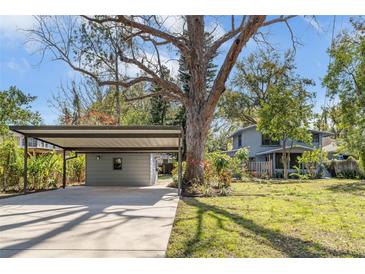 Charming home featuring a covered carport and lush landscaping surrounding the property at 206 W Minnehaha St, Tampa, FL 33604