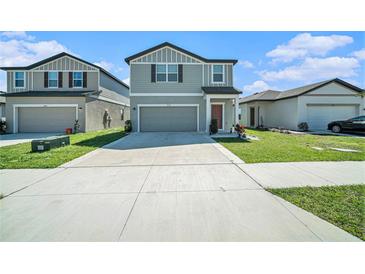 Charming two-story home with an attached garage, manicured lawn, and neutral-colored exterior with a driveway at 35542 Buttonweed, Zephyrhills, FL 33541