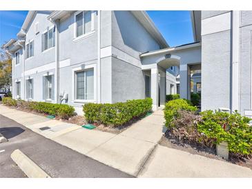 Light gray two-story condo with manicured bushes near the walkway to the main entrance at 4106 Waterside Island Ct, Tampa, FL 33617
