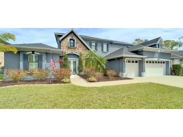 Charming two-story home featuring stone accents, a well-manicured lawn, and a two-car garage at 5115 Abisher Wood Ln, Brandon, FL 33511