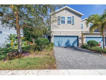 Charming two-story townhome with blue accents, paved driveway, and nicely landscaped front yard at 1109 Lady Gouldian Ct, Tampa, FL 33613