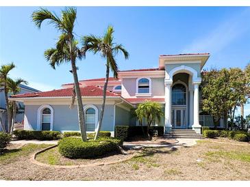 Stunning two-story home featuring a red tile roof, arched windows, and a grand entrance with elegant columns at 1423 Jumana Loop, Apollo Beach, FL 33572