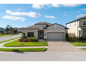 Charming single-story home with a brick-paved driveway and well-manicured lawn at 1593 Secluded Garden Ln, Lutz, FL 33558