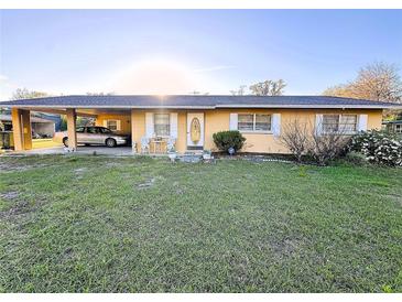 Charming single-story home with a covered carport, a well-maintained lawn, and an inviting front entrance at 18401 Hamilton Rd, Dade City, FL 33523