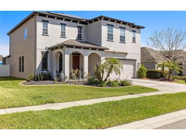 Charming two-story home with manicured lawn and a two-car garage at 5524 Shasta Daisy Pl, Land O Lakes, FL 34639