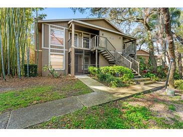 Inviting two-story home with well-maintained landscaping and exterior staircase to front door at 14211 Shadow Moss Ln # 101, Tampa, FL 33613
