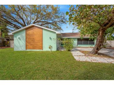 Charming home with a well-maintained lawn and unique wooden accent, enhanced by mature trees providing shade at 1710 Orange Hill Way, Brandon, FL 33510