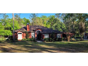 Charming single-story home featuring a brick facade, well-maintained landscaping, and inviting front entrance at 3424 Nature Trl, Brooksville, FL 34602