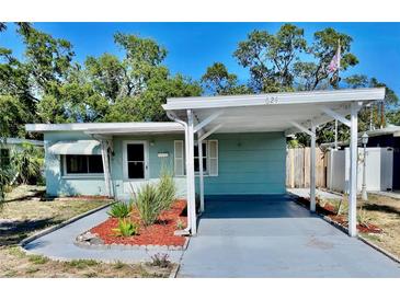 Charming single-story home featuring a carport and beautifully landscaped front yard under a bright blue sky at 624 Folsom S St, St Petersburg, FL 33707
