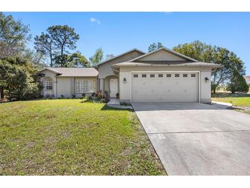 Charming single-story home with a well-manicured lawn and attached two-car garage at 6242 Gainsboro Ave, Spring Hill, FL 34609