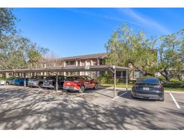 Exterior view of covered parking spaces available at the residential complex on a sunny day at 725 83Rd N Ave # 205, St Petersburg, FL 33702