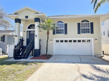 Charming two-story home with a large garage and stylish architectural details on a sunny day at 922 Michigan Ave, Palm Harbor, FL 34683