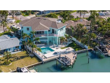 Stunning waterfront home with pool, boat dock, and lush tropical landscaping at 15904 Redington Dr, Redington Beach, FL 33708