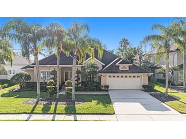 Beautiful single-story home with lush landscaping, an attached two-car garage, and a large driveway at 18823 Wimbledon Cir, Lutz, FL 33558