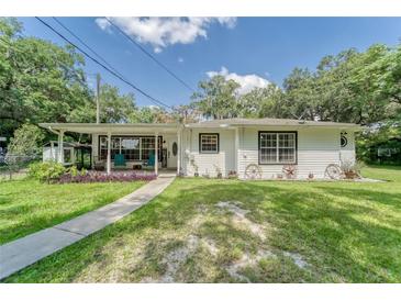 Charming single-story home with a covered porch, lush lawn, and decorative accents creating a welcoming curb appeal at 2708 De Montmollin Rd, Plant City, FL 33565