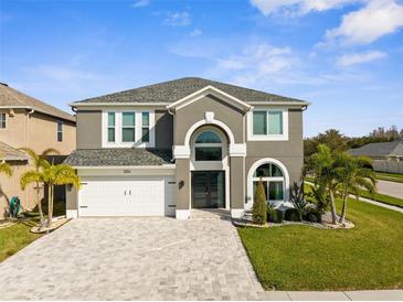 Stunning two-story home boasts a modern design, well-manicured lawn, and elegant paver driveway at 3654 Beneraid St, Land O Lakes, FL 34638