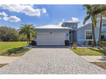 Charming light blue single-story home with a pristine garage and a paver driveway at 445 Bahama Grande Blvd, Apollo Beach, FL 33572