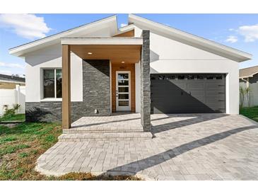 Modern home entrance with gray stone accents, wood trim, and a paver walkway at 4907 15Th N Ave, St Petersburg, FL 33710