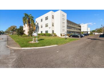 Corner view of the building exterior featuring well-maintained landscaping and parking area at 5969 Terrace Park N Dr # 203, St Petersburg, FL 33709