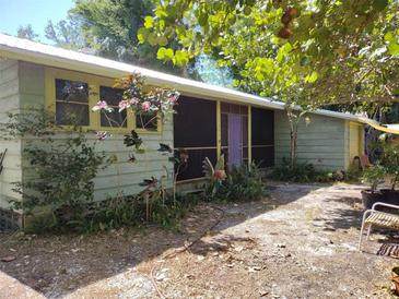 Charming single-story home featuring a screened porch and lush, mature landscaping at 1044 Virginia Dr, Sarasota, FL 34234