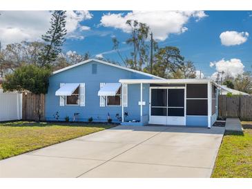 Charming blue home featuring a screened-in porch and a well-maintained front yard at 358 51St N Ave, St Petersburg, FL 33703