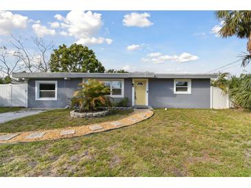 Charming single-story home featuring a well-manicured lawn, inviting walkway, and a freshly painted exterior at 4009 W Mango Ave, Tampa, FL 33616