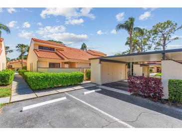 Charming home exterior featuring a red tile roof, lush landscaping, and a convenient carport at 5310 Huntingwood Ct # 40, Sarasota, FL 34235